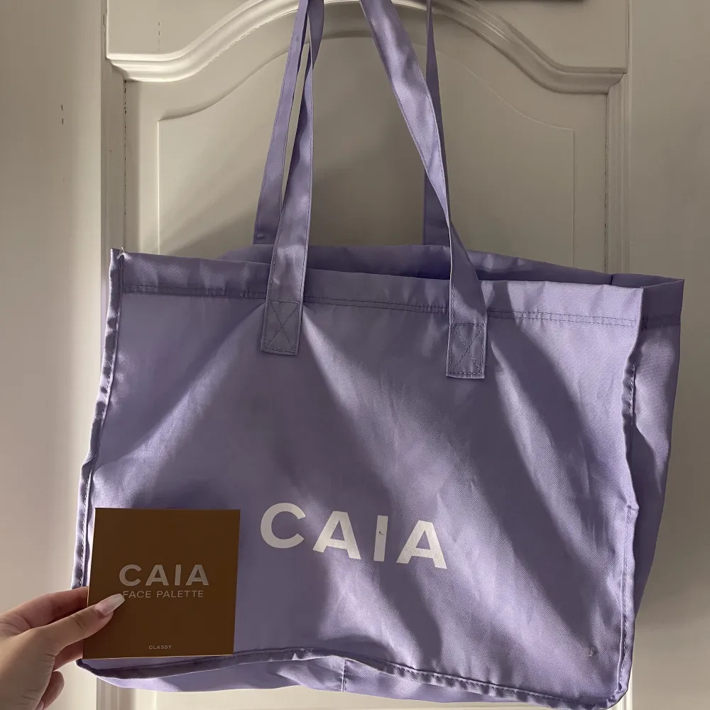 En lila Caia väska/totebag! Se sista bilden för att få en bättre storleksbild, finns små fläckar men som säkert går bort i tvätten (Skriv privat så skickar jag bilder)! Tänker mig runt 200kr + frakt annars bud 💜. Väskor.