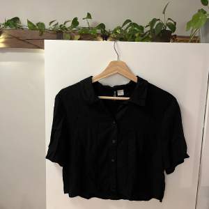 Säljer en svart croppad skjorta från H&M Divided i storlek S. Den har endast använts ett par gånger. 
