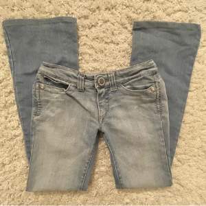 Lågmidjade bootcut jeans Supersnygga SOS jeans, köptes här på plick men var tyvärr för små. De är i strl 34 men skulle säga att en 32a också skulle kunna passa. En liten fläck längst ner på benet. Skriv för fler bilder🩷