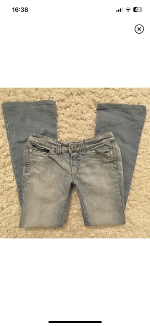 LÅGMIDJADE JEANS! - Lågmidjade bootcut jeans Supersnygga SOS jeans, köptes här på plick men var tyvärr för små. De är i strl 34 men skulle säga att en 32a också skulle kunna passa. En liten fläck längst ner på benet. Skriv för fler bilder🩷