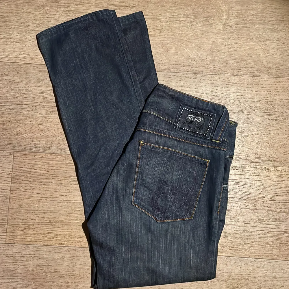 Vintage jeans från bikbok som inte säljs lägre med jätte snygga detaljer på baksidan💕 Innebenslängd: ca 72 cm, midja tvärs över: 41cm. Färgen på stenarna har gått bort lite men det syns inte💞 Skriv för fler bilder eller frågor💓. Jeans & Byxor.