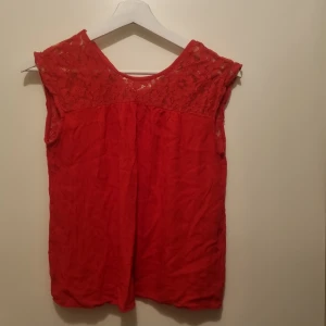 Röd topp - Härlig röd topp med spetsdetaljer, liksidig fram och bak.