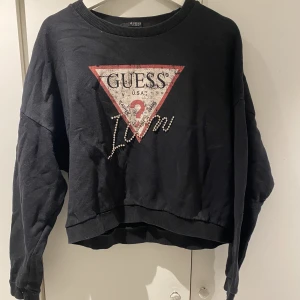 Guess sweatshirt med tryck - Svart sweatshirt från Guess med tryck, står ingen storlek men skulle säga M. Är inte säker på om den är äkta eftersom jag köpte den begagnat, därav priset:)