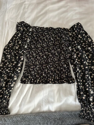 Blooming blus från Neo Noir - Blus med lite större ärmar och ribbad midja. Från Neo Noir. Storlek S/XS.