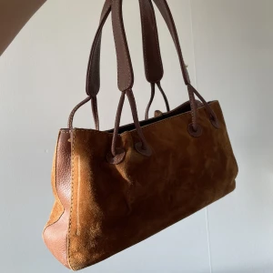 mockaväska - säljer denna handväska i mocka, supersöt! perfekt storlek enligt mig, rätt liten väska men man får plats med allt. superfint skick!