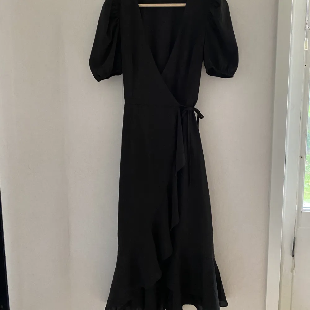 Jättefin svart omlottklänning med puffärm. Endast används någon enstaka gång. Säljer pga blivit för liten.. Klänningar.