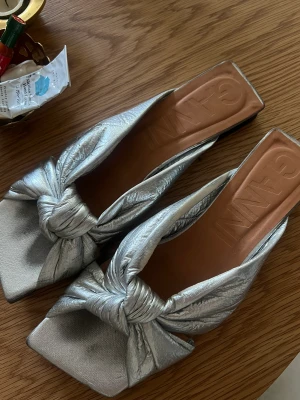 Ganni sandaler  - Säljer ett par otroligt snygga sandaler från ganni. Inköpta i Juni i somras och endast använda 2 gånger. Jag har storlek 39 men i dessa 40 pågrund av ganska tajta. Jag skulle säga att de passar 38-40 beroende på storleken på foten!