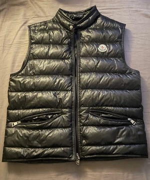 Moncler väst - Säljer min fina Moncler väst då den är för liten. Perfekt skick. Moncler påse tillkommer även. Köpt för 7999kr på NK i Stockholm. Vid frågor och funderingar är det bara att höra av sig!