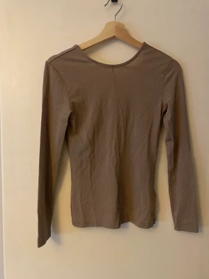 Glittrig topp - Glittrig topp från Tiger of Sweden, hög i kragen framtill och låg i ryggen, går säkert att vända på och ha åt andra hållet.