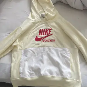 Vi säljer en Nike sportswear hoodie. Den är i storlek xs. Beige med röd text och vita fickor. Den har aldrig använts och lappen sitter kvar.VIKTIGT: vi kommer inte att betala för frakt