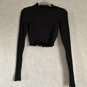 svart topp - svart långärmad tröja med mockneck från monki. ribbad i materialet och har salladsfåll vid varje kant. använd några gånger men har inga defekter.