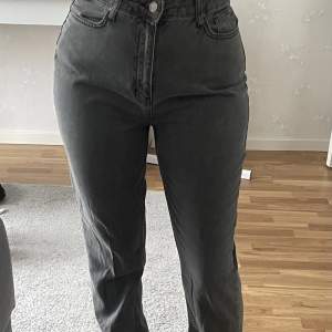 Ett par gråa jeans med slit som är i storleken 38 
