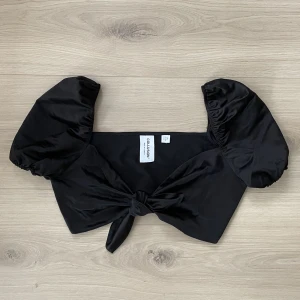 Satinblus croppad - Supersöt satinblus med knytning fram och puffärm. Använd endast en gång så jättefint skick