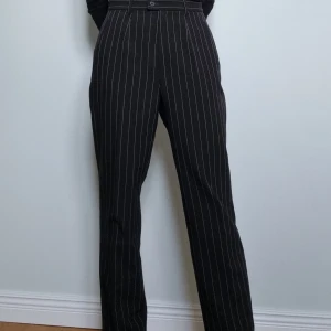 Svarta randiga kostymbyxor från Cero - Sköna och tunna kostymbyxor från Cero! Köpta second hand men knappt använda av mig så de är i nyskick. Passar troligtvis storlek M också! Midjemåttet är 82 cm.