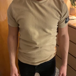 T-shirt - Beige stickad t-shirt från Calvin Klein. I bra skick.  Storlek M men sitter lite tight. 