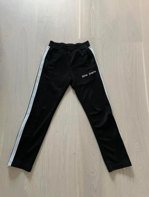 Palm angels byxor small - Säljer Palm angels byxor  Fint skick! Size Small  Cond 7-8/10, texten har spruckit men inget som lossnar!  Allt kvar från köp med kvitto och påse samt tags!  Pris 1300kr