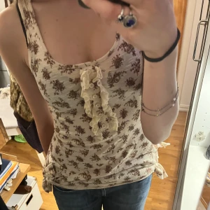 Blommig topp - Kan knytas på sidorna, bra skick