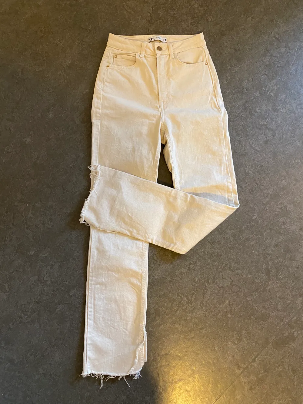 Skitsnygga jeans från Zara i beige/krämvit med slit och hög midja⚡️ett litet märke på fickan där bak, se sista bild. Jeans & Byxor.