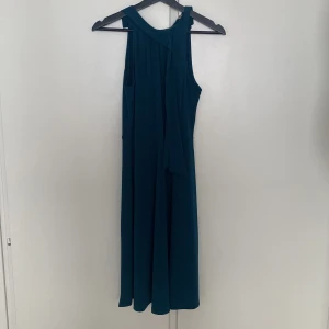 Klänning - Mörkblå/grön klänning med två band upptill, går att knyta, men också bara att ha hängandes.