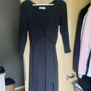 Klänning  - Svart knälång klänning med slits från hollister. Storlek S. Använd ca 2-3 gånger. Fint skick. Mjuk och skön till vår/höst. 80kr plus frakt 40kr. 
