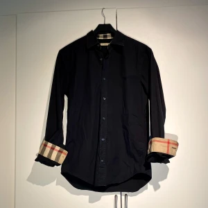 Burberry Embroided Skjorta Svart - Hej, säljer den väldigt populära Burberry skjortan i svart färg. Perfekt i alla lägen, vardag som fest. Nypris 5600kr på Burberrys hemsida. Storlek Small och True To Size. Bra skick, inte ny, sparsamt använd. Pris kan diskuteras. Hör av dig vid intresse!