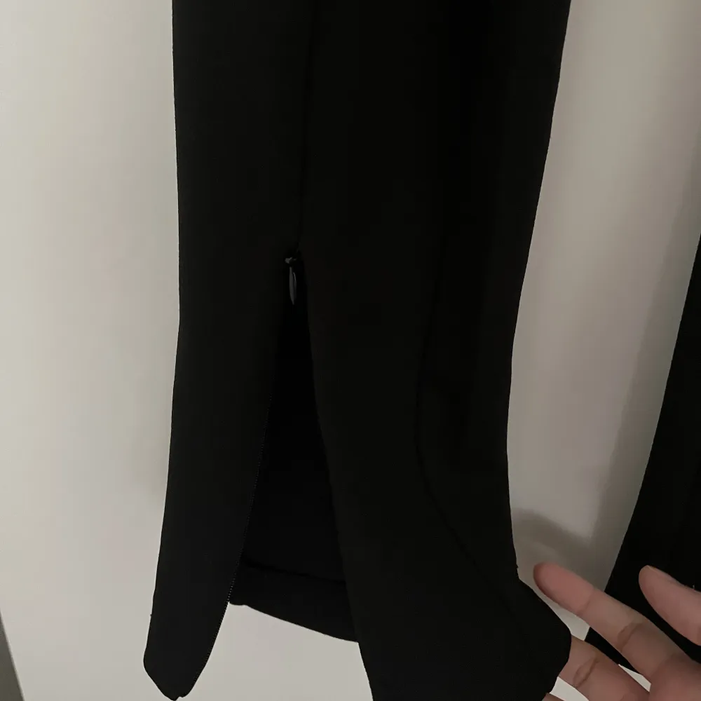 Säljer ett par svarta kostymbyxor som är använda väldigt fåtal gånger. Dem har slit där nere som man kan justera själv!. Jeans & Byxor.