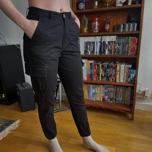 svarta cargobyxor  - Svarta cargobyxor från carlings. Använts sparsamt i ca 4 månader sedan har de endast legat nerpackade. Fickor på benen, men dock inga bakfickor.  Relativt korta, personen på bilden är 166cm. ✨