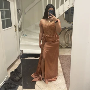 Balklänning/fest - Säljer denna balklänningen. Den är rosé guld och har paljetter på brösten och är öppen vid benet. Ej använd 