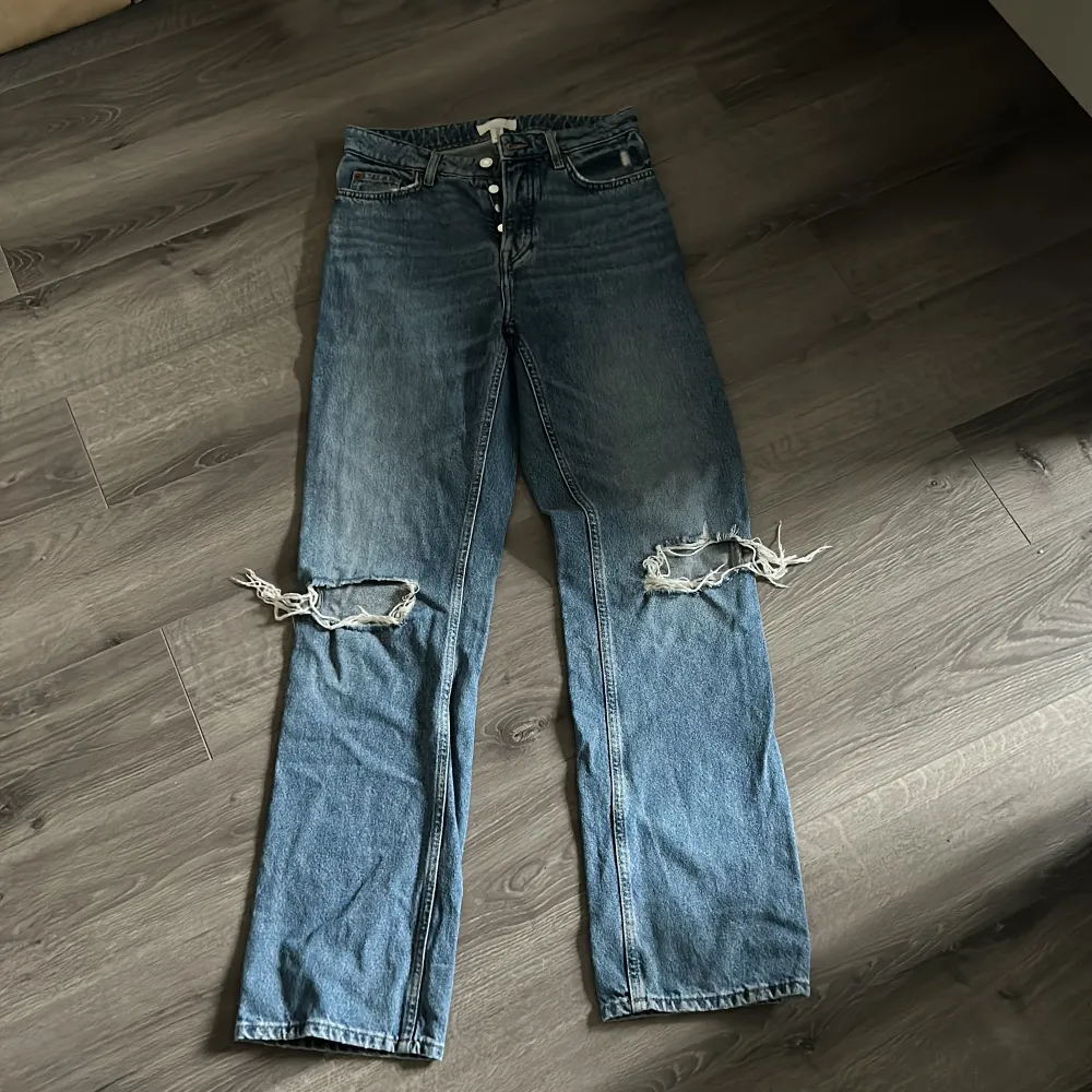Blåa raka jeans med hål i knäna från hm. Säljer dem för att dem är förstora. Är i storlek 38 men mer som 40 skulle jag säga.. Jeans & Byxor.