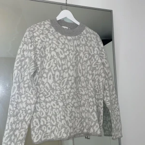 Gråvit leopard stickad tröja - En tunnare stickad tröja som är knappt använd. Storlek L men är en bra oversize på M.