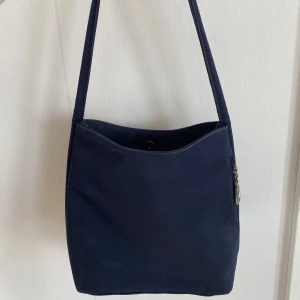 Vintage väska - Vintage axelremsväska från 90talet. Mörkblå. Dragkedjan på sidofickan lite sliten.