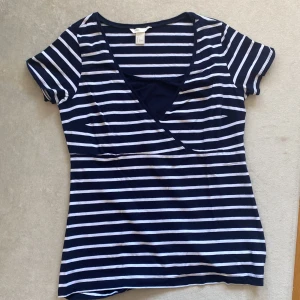 Randig t-shirt, H&M MAMA - En randig och bekväm t-shirt från H&M MAMA med fin skärning vid bysten.