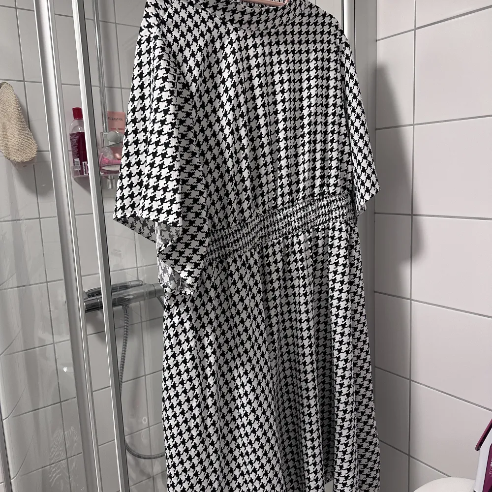 Svartvit houndstooth klänning  Satin, polo neck   Fint skick, använt bara 2 gånger  Storlek runt 52, elastisk midja . Klänningar.