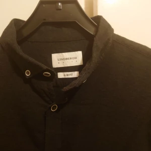 Ny Lindbergh white skjorta  - Helt ny snygg stilren Lindbergh design i mörkgrå färg med vit/ svarta knappar Storlek Large  Mitt pris endast 149 kr plus frakt 