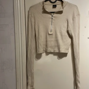Tröja med zipup  - En beige tröja från Gina tricot i storlek M, passar däremot allt från S-L då den är stretchig. Använd ett fåtal tillfällen men kommer ej till användning därav säljes den