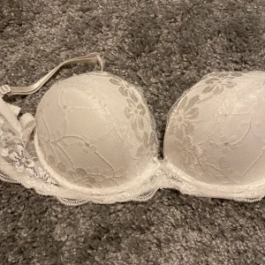 Bh - Knappt använd ungefär 1-2 gånger. Så ungefär nytt skick. Väldigt fin! Ingen push up men ger ändå ett litet tryck. Lite spets på och söta rosetter. En mellan bysten och en på vardera sida vid bandens början. 