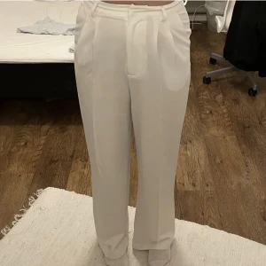 Vita raka kostymbyxor  - Vita raka kostymbyxor från bikbok i Stl 40. Modellen på bilden är 173cm lång.  Byxorna är använda en gång på en skolavslutning. Nypris 400kr