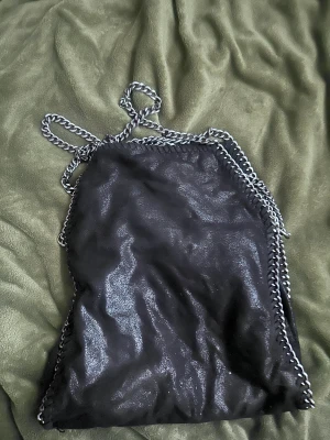 Stella McCartney väska!! Kopia!!!! - Säljer min svarta fina Stella väska pga att den inte kommer till användning!! I ett väldigt bra skick och använt endast 1 period🌼🌼 medel stor och är otroligt fin att ha på axeln!! 