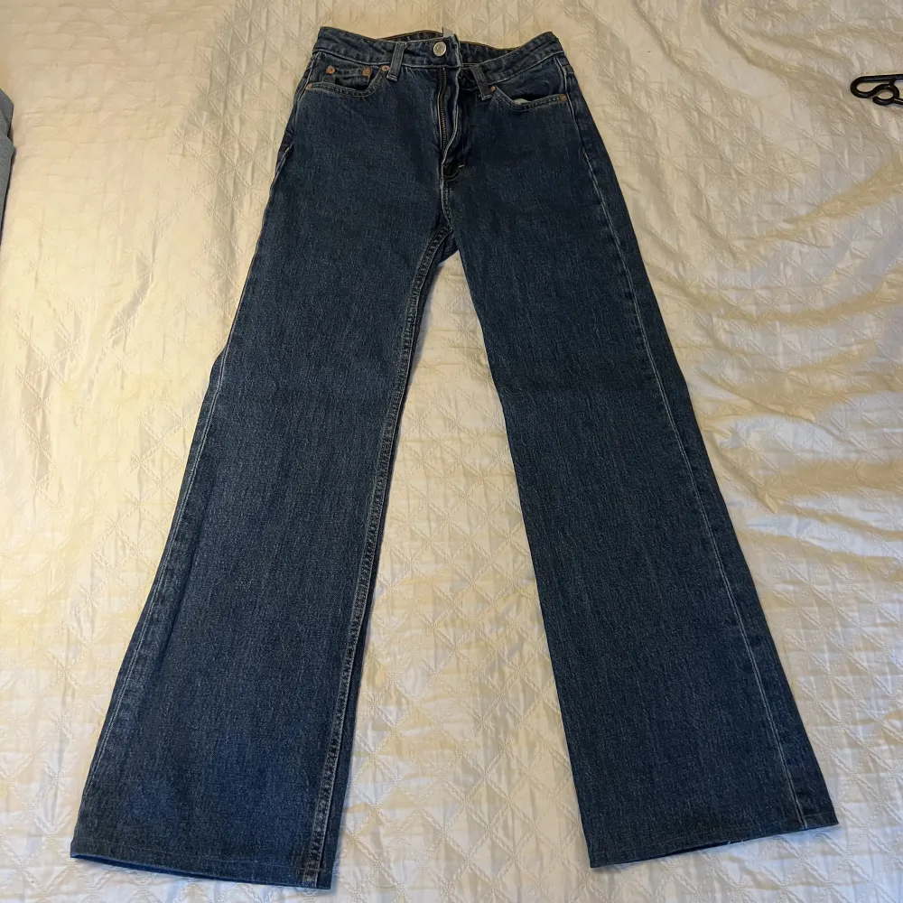 Ett par jeans från Weekday i modellen Glow. De är använda 1 gång så de är i fint skick. OBS! Jag har sytt upp dem så de skulle passa mig som är cirka 155 cm lång, jag är amatör och kan inte garantera att det är en perfekt söm. Köps i befintligt skick.. Jeans & Byxor.