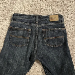 Suupersnygga bootcutjeans från Tommy Hilfiger  - Suupersnygga bootcutjeans från Tommy Hilfiger med en del slitningar längst ned vilket jag bara tycker är snyggt. Kan skicka bild om det önskas💕 Lowwaist med innerbenslängd 75 cm, W25, L32