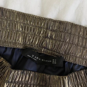 Guldiga byxor från Zara - Ett par lite annorlunda byxor från Zara i guld. Köpte dem via Sellpy. I fint skick!