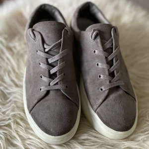 Jennie-Ellen sneakers - Skitsnygga sneakers från Jennie-Ellen. Sparsamt använda, men såg nu att det har gått upp lite av gummit i hälen (bild 3). Ingenting jag tänkt på tidigare, men därav priset. Passar för dig som brukar ha 37-38 i storlek.  Modell: Bae Material: koskinn