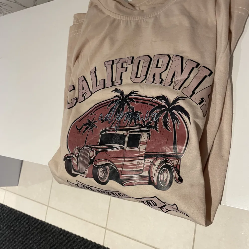 En beige t-shirt med ett California tryck på framsidan. Bigsize tröja, men är i storlek S. Skönt material. I nytt skick, använt två ggr. 🌸. T-shirts.