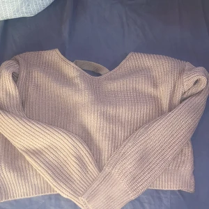 trästickas tröja  - rosa/beige stickad tröja med små glitter kulor på baksidan samt knytning på ryggen 
