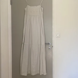 Lång sommarklänning  - En ljusgrå/vit sommarklänning som går till anklarna på mig (167cm)  Justerbara axelband  Passar både M, S och XS  Perfekt till allt! 
