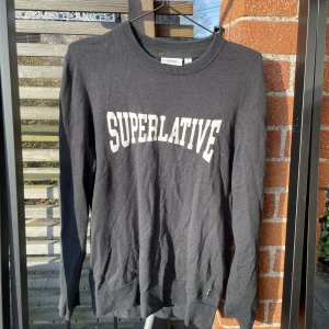 Ulltröja Superlative - Svart ulltröja med trycket Superlative från wesc, storlek Mens S / Womens M Säljes i befintligt skick