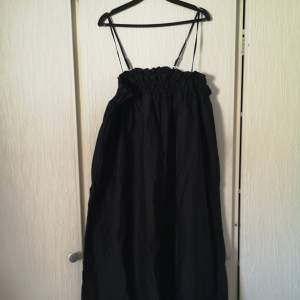 Helt ny, oanvänd svart lång klänning med ställbara axelband. Rymlig