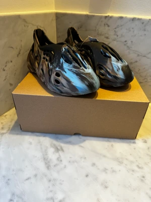 Yeezy Foam RNR MX Cinder - Köpt från adidas confirmed. Skorna är deadstock alltså inte använda. Storleken är 44 1/2. Pris: 1500kr. Box och kvitto medföljer. Köpare står för frakt.