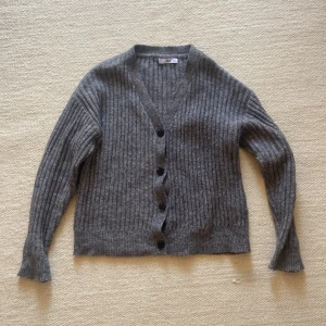 Stickad kofta i ull  - Stickad kofta från ellos. Sparsamt använd i fint skick. Strl 38