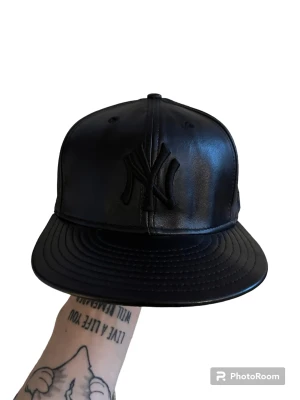 Fitted keps - Fitted keps i fakeläder. Aldrig använd. Vintage. Storlek 57.7cm och TTS. New era. PM om ni har fler frågor eller vill ha fler bilder.